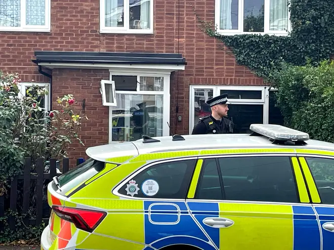 A police officer outside a property in Main Street, Stonnall, Staffordshire, after a man died after being bitten by two dogs