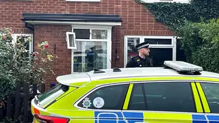 A police officer outside a property in Main Street, Stonnall, Staffordshire, after a man died after being bitten by two dogs