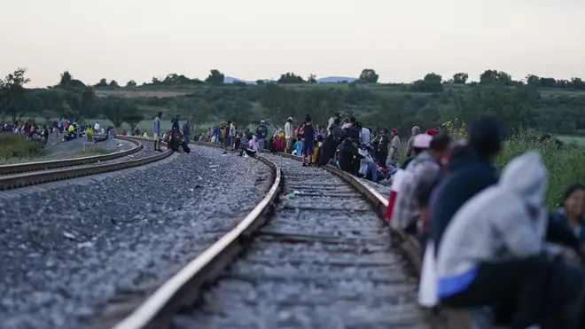 Migrants wait along rail lines in Mexico