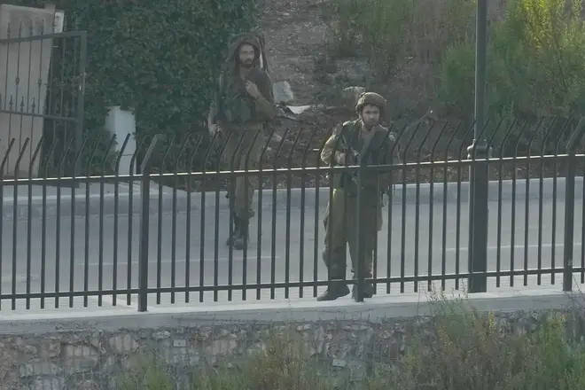 Israeli soldiers patrol a street in the Israeli town of Metula