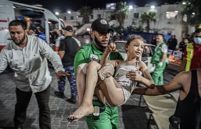 A paramedic carries a girl after she was pulled from the scene of bombing in Gaza on Monday
