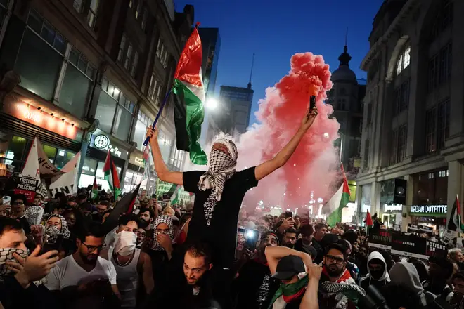 People take part in a Palestine Solidarity Campaign demonstration near the Israeli Embassy, in Kensington