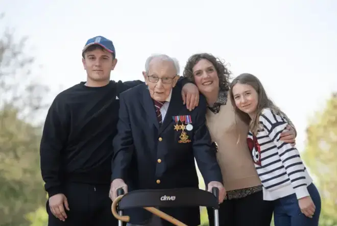 Captain Tom Moore, with (left to right) grandson Benji, daughter Hannah Ingram-Moore and granddaughter Georgia, at his home in Marston Moretaine, Bedfordshire, after he achieved his goal of 100 laps of his garden