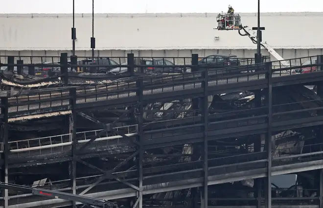 Burned out cars are pictured in a charred section of Luton Airport's Terminal 2 car park