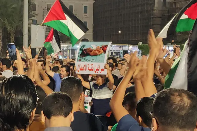 People lift placards and Palestinian flags during a protest in Libya's capital Tripoli