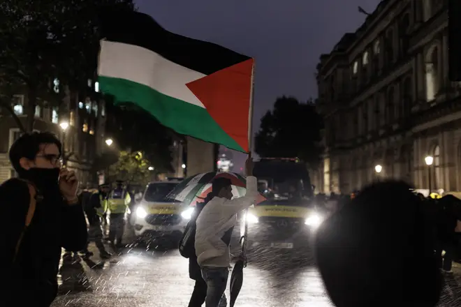 Pro-Palestinian supporters hold up flags as they attend a vigil for the victims of the Al-Ahli Arab Hospital explosion at Downing Street