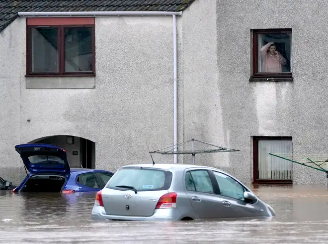 A person looks from a window at floodwater in Brechin as Storm Babet batters the country