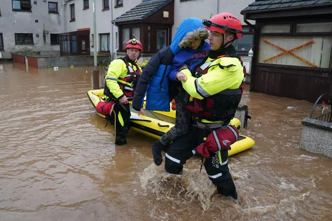 Rescuers take a boy to safety after Storm Babet hit Brechin