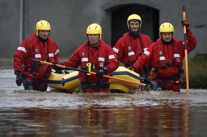 Members of the coastguard rescue team wade through the flood waters to check on people in their houses on October 20, 2023 in Brechi