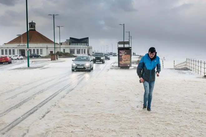 Sea foam covers the shore and promenade on Aberdeen Beach.