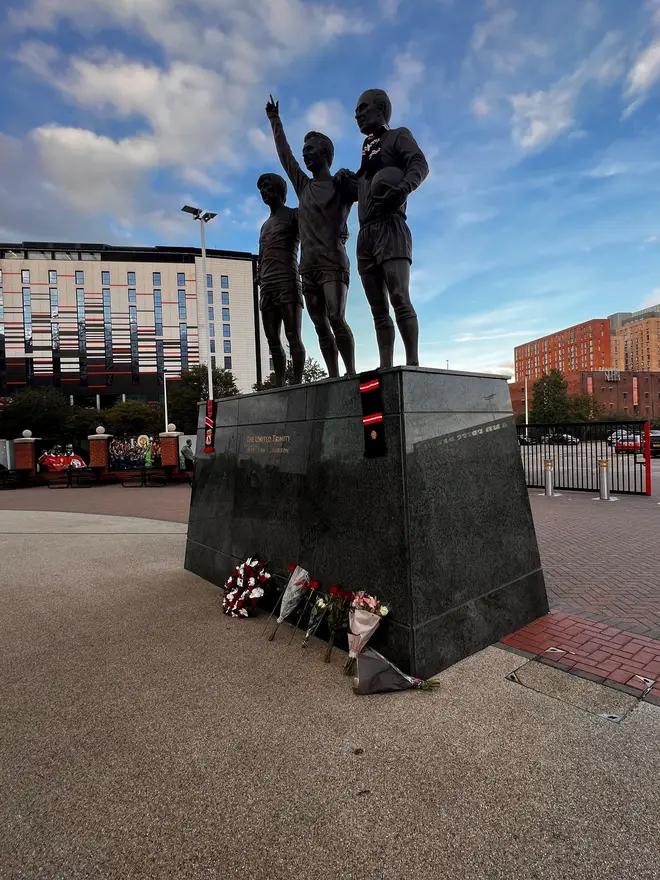 Flowers left by The United Trinity statue at Old Trafford in Manchester.