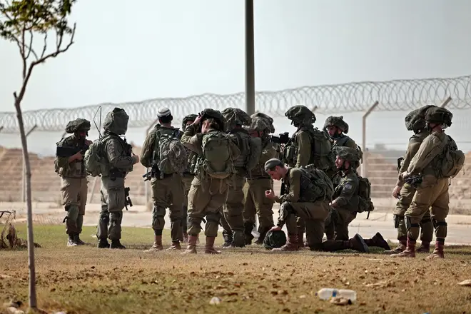 Israeli soldiers gather to patrol Kibbutz Beeri along the border with the Gaza Strip