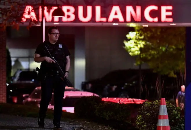 An armed police officer guards the ambulance entrance to the Central Maine Medical Center in Lewiston, Maine