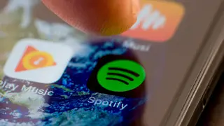 Person using phone to access Spotify app