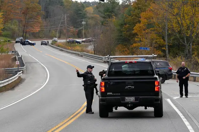 Police officers speak with a motorist at a roadblock in Lisbon, Maine during the manhunt