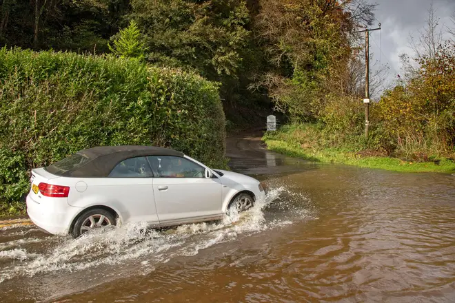 Car trying to navigate a flooded road in Swansea