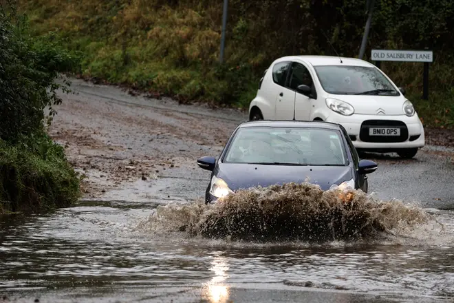 A car drives along a flooded road in Romsey, southern England