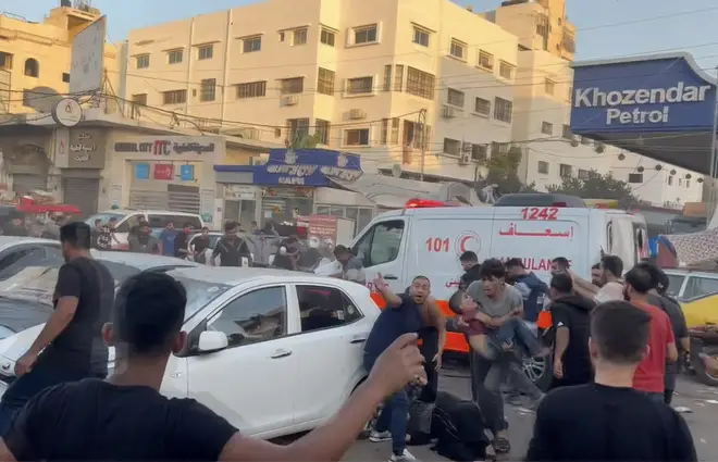 People gather around an ambulance damaged in an Israeli strike