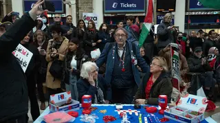 Royal British Legion poppy sellers look on as they are surrounded by people staging a sit-in inside Charing Cross train station during a pro-Palestinian demonstration on November 4