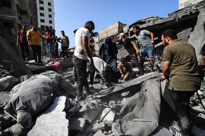 People inspect the rubble of buildings destroyed in Israeli airstrikes in Gaza City