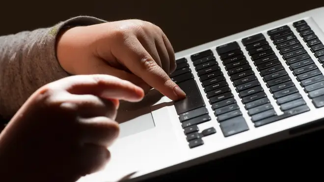 A child's hands on a laptop keyboard.