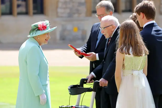 Captain Tom receiving his knighthood from The Queen