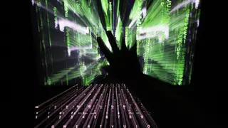 A zoom burst photo of a user touching the screen of a laptop displaying a ‘Matrix’-style screensaver