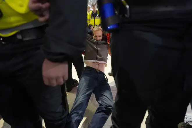 Police offiers detain a pro-Palestinian protester who took part in a sit-in demonstration at London's Waterloo Station calling for a ceasefire in Gaza.