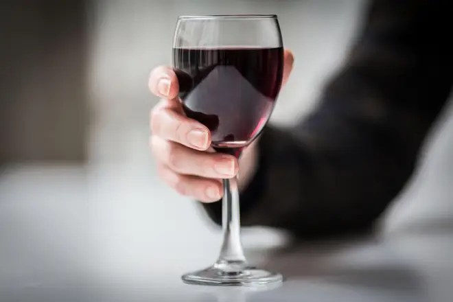 Woman holding a glass of red wine (file image)