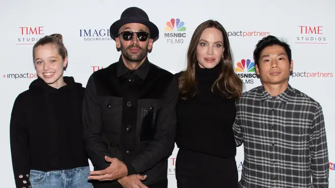 Angelina Jolie with Pax Jolie-Pitt (far right) attend The Los Angeles Premiere of 'Paper and Glue: A JR Project' alongside Shiloh Jolie-Pitt (far left) and JR. Credit Image: Billy Bennight/ZUMA Press Wire