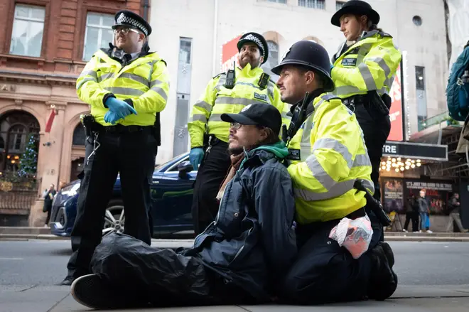 Climate activists from Just Stop Oilpropped up by Met police officer