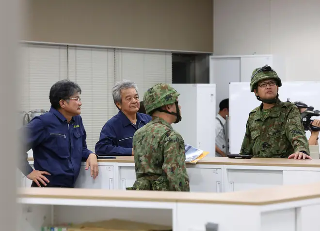 Officials of Ishigaki Fire Department and Japan Self-Defense Force member gather information about North Korea's missile in Okinawa Prefecture