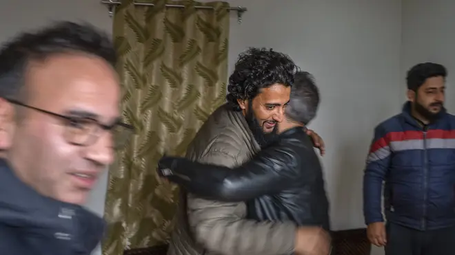 Fahad Shah hugs a colleague after his release