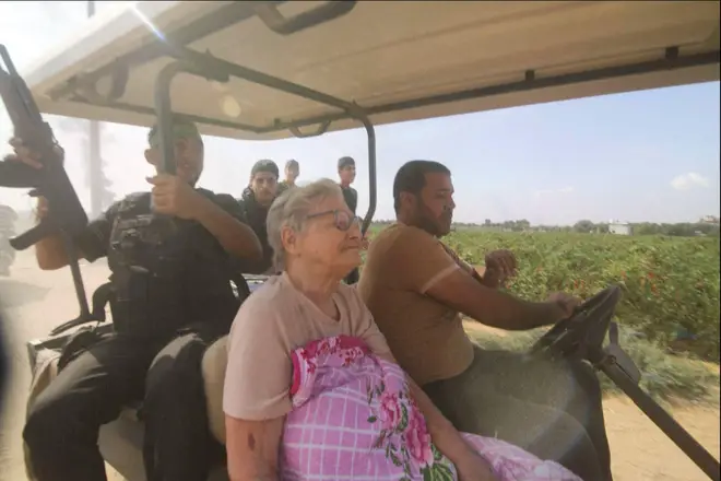 In this still image taken from video, Hamas' militants transport Yaffa Adar, 85, into Gaza