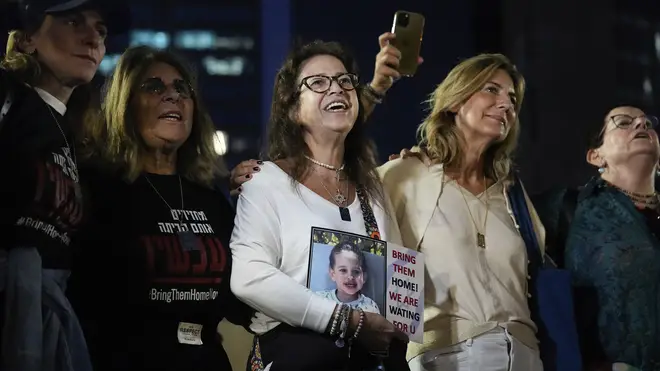 People in Tel Aviv react as they hear the news of the release of 13 Israeli hostages held by Hamas in the Gaza strip