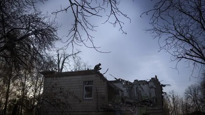 A Ukrainian serviceman stands on top of a damaged school following a Russian drone attack in Kyiv