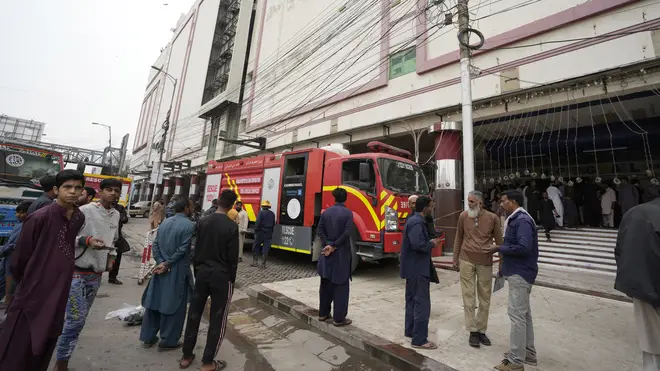 People gather in front of a building in Karachi following a fire