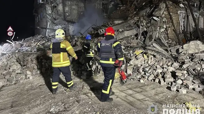 Rescuers work at the scene of a building damaged by shelling in Pokrovsk, Ukraine, on Thursday