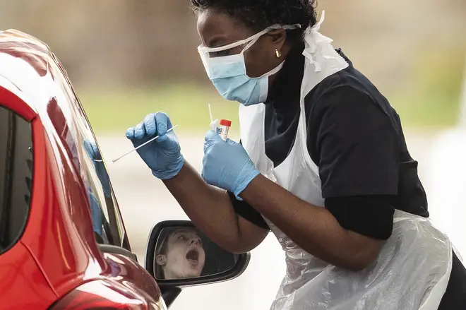 A nurse takes a swab at a Covid-19 Drive-Through testing station