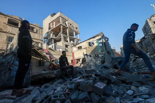 Palestinians inspect a building damaged during Israeli bombardment