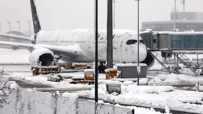 A Lufthansa aircraft parked at the snow-covered Munich airport in Germany