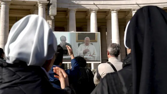 Crowds watch Pope Francis on a giant screen in St Peter's Square