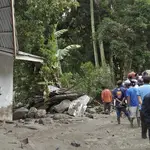 Rescue workers inspect the damage in Simangulampe village