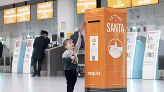 A young traveller posts a letter to Santa in one of easyJet's special post boxes