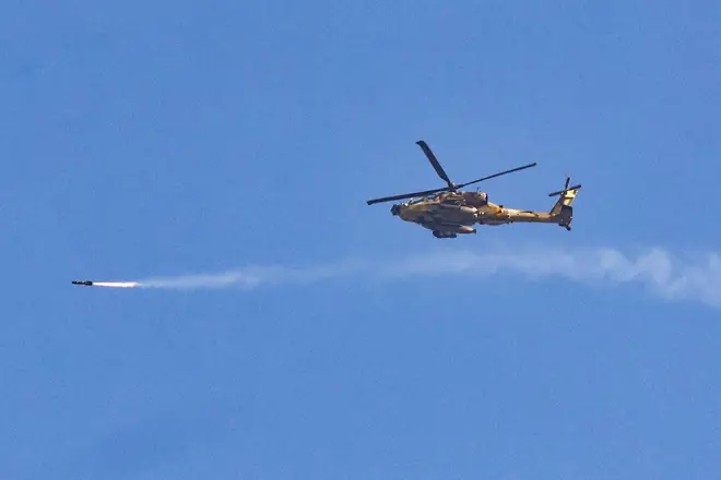An Israeli air force attack helicopter firing a missile while flying over the border with Gaza