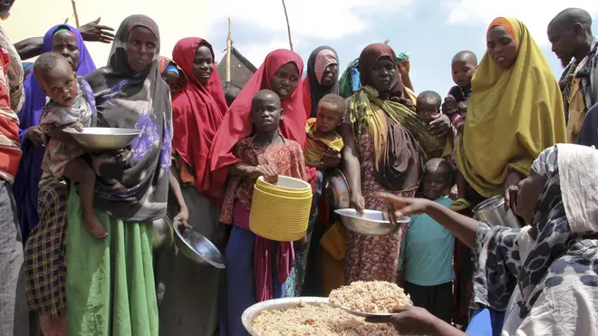Newly arrived Somalis, displaced by a drought, receive food at makeshift camps in Mogadishu