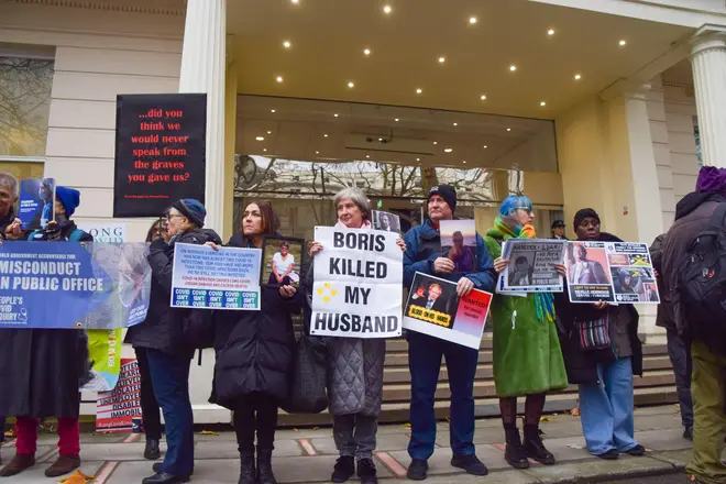 Protesters and bereaved family members stand outside the Covid-19 Inquiry Hearing Centre