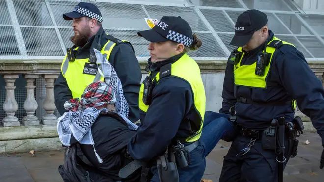 London, UK. 21 Oct 2023: A pro-Palestinian protester in Whitehall is carried away by police after being arrested for refusing to remove his face covering at a demonstration against Israeli attacks on Gaza.