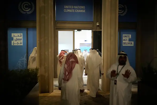 Delegates walk into a meeting at Cop28 early on Wednesday morning