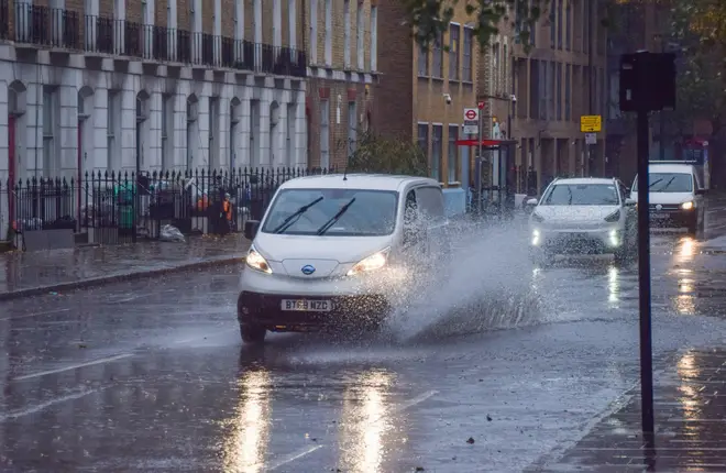 A van splashes through a large puddle amid recent stormy weather